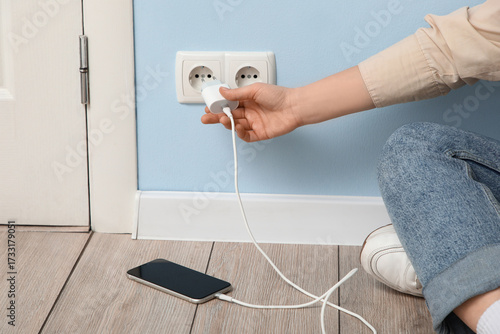 Woman unplugging mobile pho...