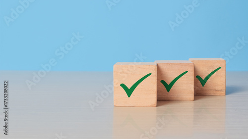 Checklist concept. Green correct sign and tick check mark to wooden cube block with copy space. Quality and ISO symbol. Wooden cube with green checkmark icon.