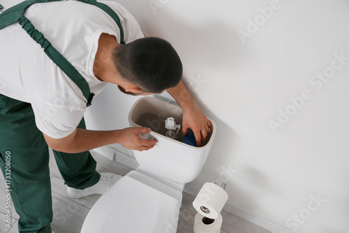Male plumber replacing fill...