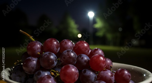 Bowl of Red Grapes Bathed in the Moonlight Awaiting Consumption Outdoors