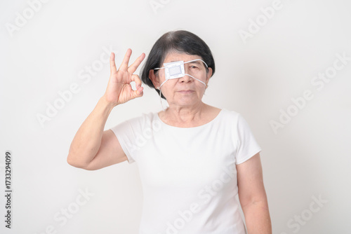 Elderly Woman with Eye protecting by Eye Pad for concepts of Eye disease, Cataract, Glaucoma, Age Related Macular Degeneration, Diabetic Retinopathy, Vitreous, Conjunctivitis, World Glaucoma day