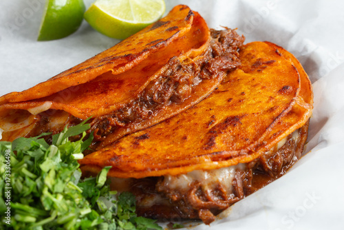 Photos A view of two birria tacos.
