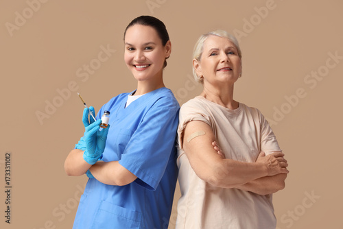 Senior woman and doctor with vaccine on beige background