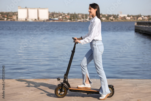Young woman riding electric...
