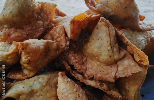 Delicious crispy golden brown samosas piled together freshly fried and ready to serve. traditional Asian street food snack made with this pastry filled and deep fried until cruchy, south Asian street 