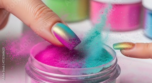 Closeup of a manicured fingernail dipping into vibrant cosmetic powder
