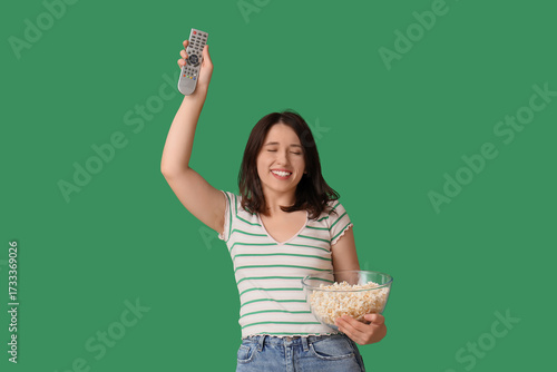 Young woman with TV remote ...