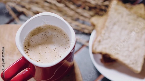 Hand put a red cup of coffee on wooden plate in morning and feeling fresh ready to work.
