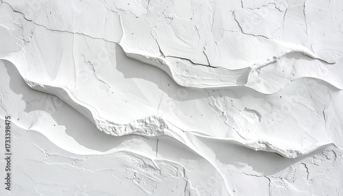 Textured white surface with layered waves and deep shadows, resembling carved terrain