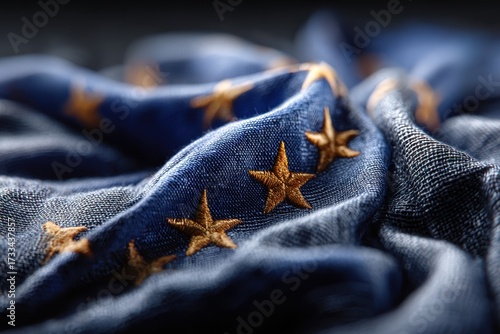 Close-up of european union flag showing detailed embroidery and stitching, golden stars set against a blue background with fabric texture creating soft folds