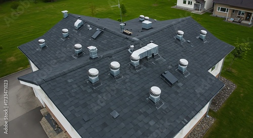 Overhead view of a residential building roof with multiple ventilation systems