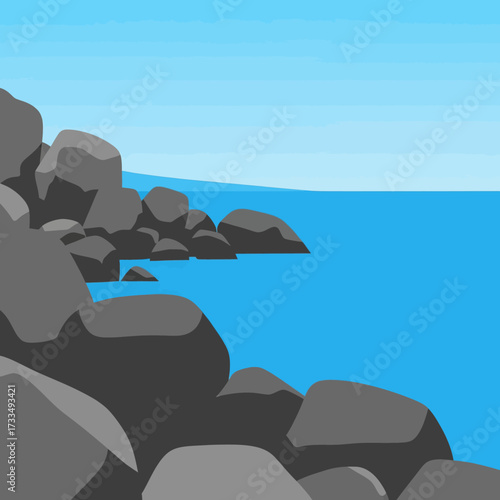 A rocky coastline meets the bright blue ocean under a clear sky.