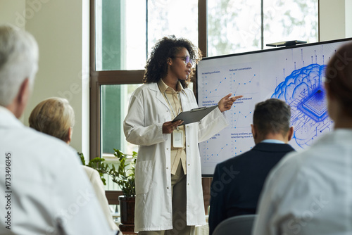 Fotografie Young Black woman presenting scientific data to group of middle aged and senior