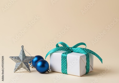 A white gift box with a green bow and blue ornaments