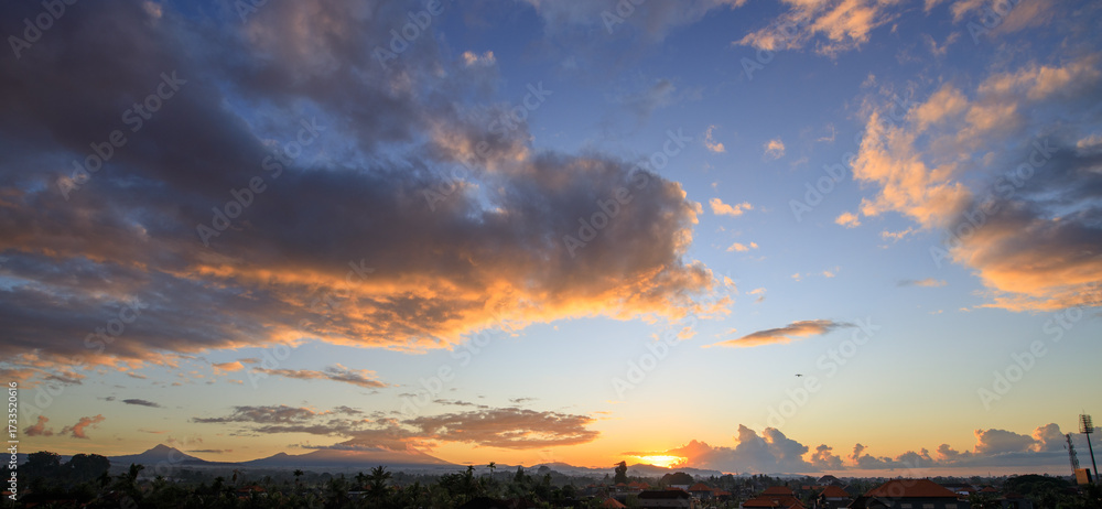 Fototapeta premium The sky is filled with clouds and the sun is setting