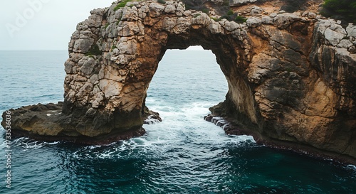 Magnificent natural rock archway formation embracing the sea with crystal clear water creating a