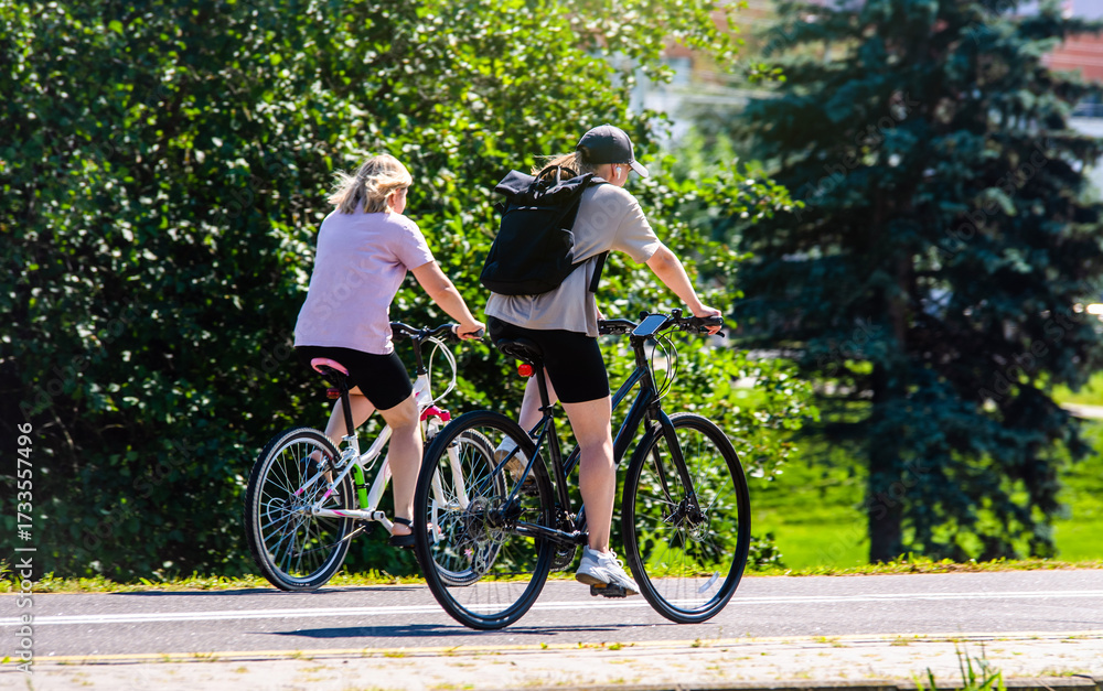 Obraz premium Cyclists ride on the bike path in the city Park 