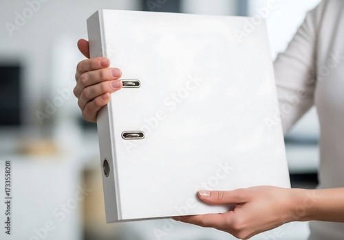 Presentation of a pristine white binder held by a person emphasizing organization and paperwork holding a white folder