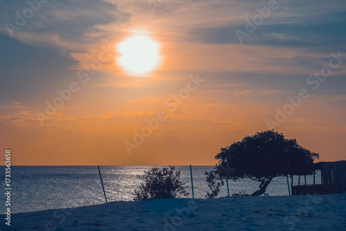 Floating in the waves at sunset, sun just above horizon, going down, orange sky, tranquil sea. Peaceful moment, vacations, summer mood. Dominican Republic. Horizontal video.