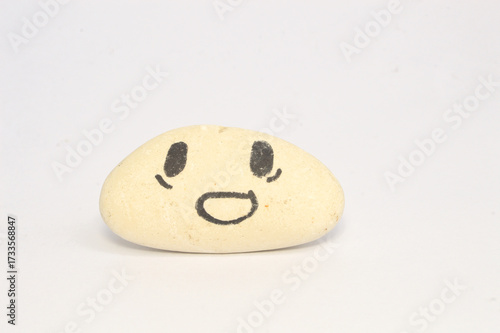 white pebble Stone with Smiling Face Cartoon. Serene, Balancing Body, Mind, Soul and Spirit. Mental Health Practice