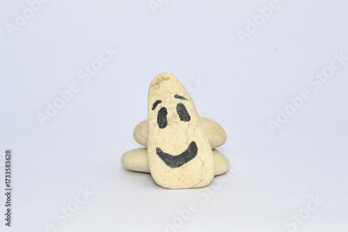 white pebble Stone with Smiling Face Cartoon. Serene, Balancing Body, Mind, Soul and Spirit. Mental Health Practice