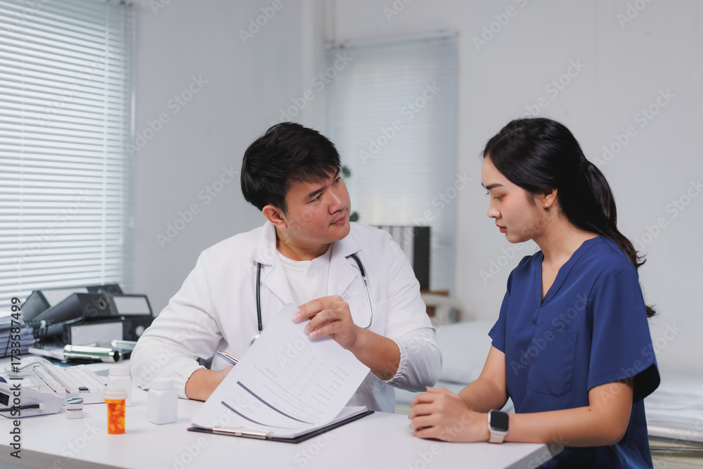 Fototapeta premium Doctor explaining medical report to nurse in hospital room