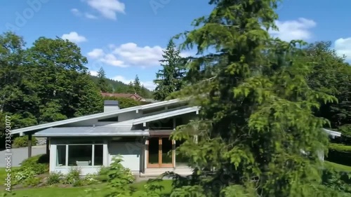 Wallpaper Mural Modern house with a slanted roof surrounded by green trees and a blue sky. Torontodigital.ca