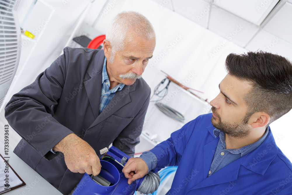 Obraz premium senior worker with student in the garage