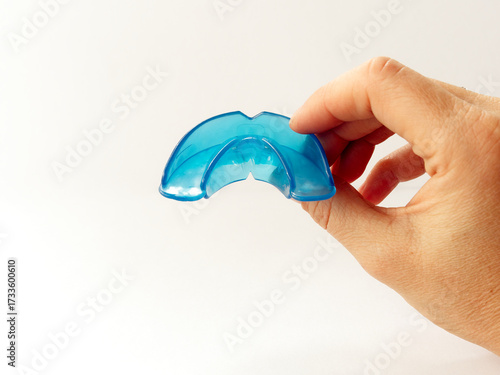 Hand holds dental simulator for teeth alignment. dental trainer equalize growing teeth, correct bite Teen and child orthodontic oral health care concept. Mouthguard, brace