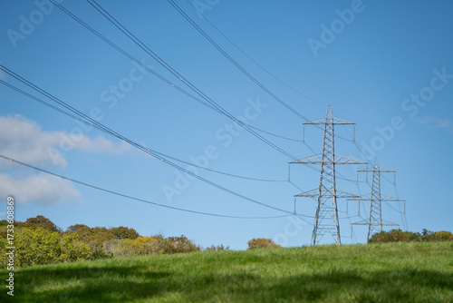 National grid electricity pylon against a blue sky. Power generation and infrastructure. Electricity network and power distribution. 
