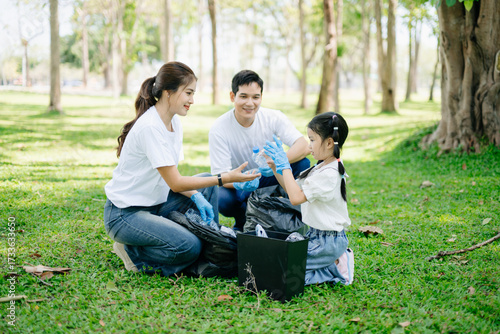 Quadro em tela Asian parents and child collect trash in the forest, promoting recycling, unity, and ecology
