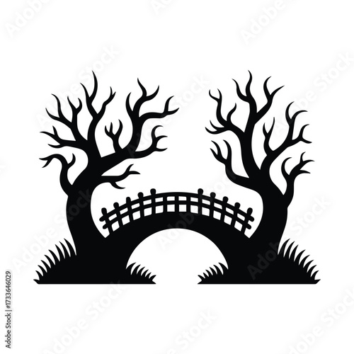 Silhouette of a spooky bare tree arching over a bridge with a picket fence and grass silhouette