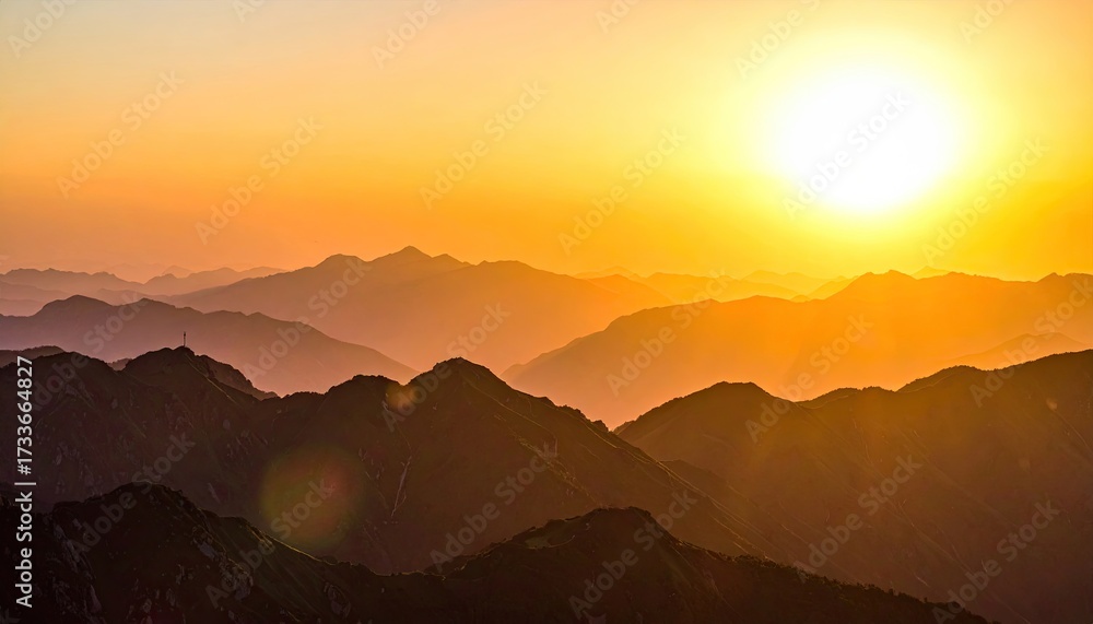 Obraz premium Golden hour illuminates layered mountain ridges under a vibrant, sun-drenched sky