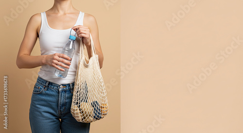 Sustainable shopper holds fresh water and goods in reusable net bag for eco-conscious lifestyle