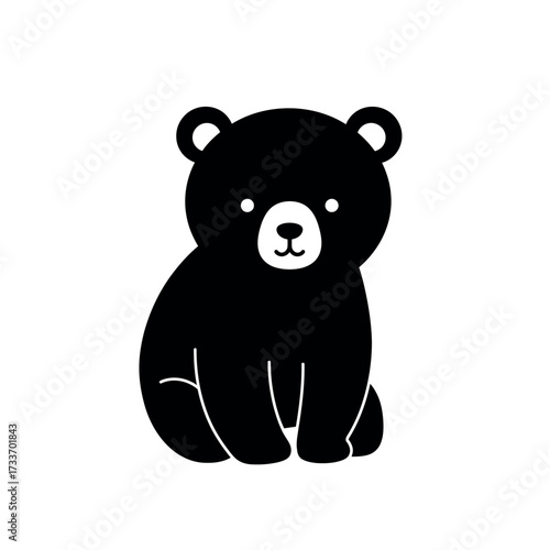 Cute black bear cub sitting and looking forward.