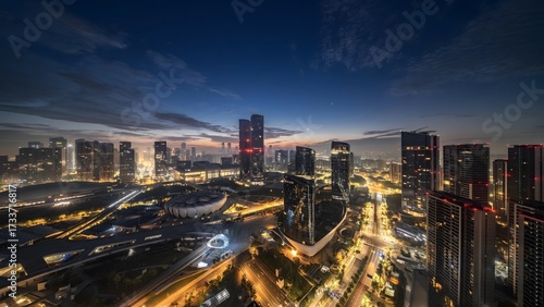 Aerial twilight view of illuminated Hangzhou cityscape with modern skyscrapers and dramatic traffic trails