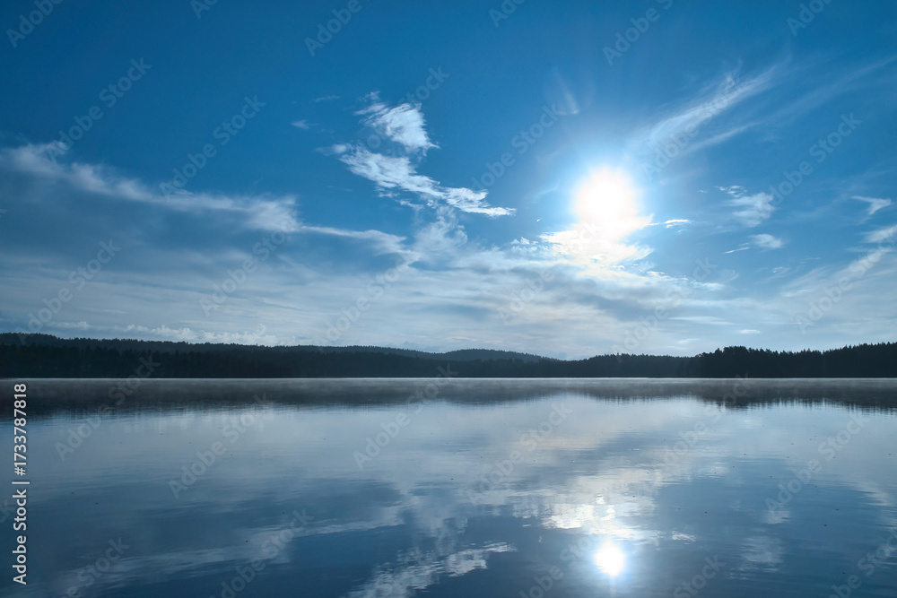 Fototapeta premium Sunset at the lake with reflection and forest, peaceful evening atmosphere