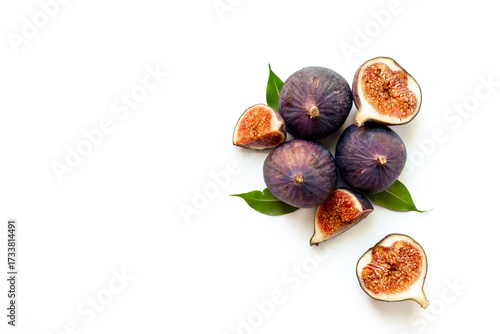 Purple ripe figs fruit and slices with green leaves top view on a white background