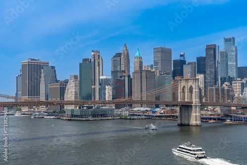 Brooklyn Bridge and Manhattan skyline with ferries on the East River, New York City, USA.