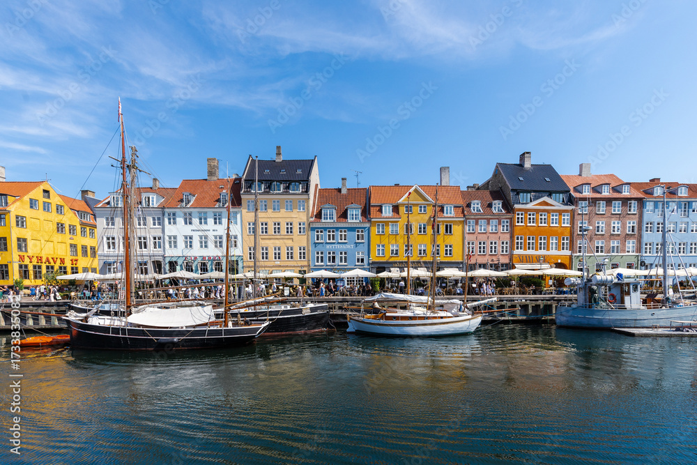 Fototapeta premium Copenhagen, Denmark 07-20-2025 The historic waterfront Nyhavn is a canal in the centre of Copenhagen and known for its brightly colored buildings, historic ships and the author Hans Christian Andersen