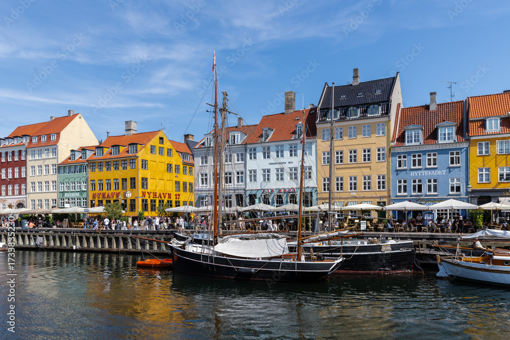 Fototapeta premium Copenhagen, Denmark 07-20-2025 The historic waterfront Nyhavn is a canal in the centre of Copenhagen and known for its brightly colored buildings, historic ships and the author Hans Christian Andersen