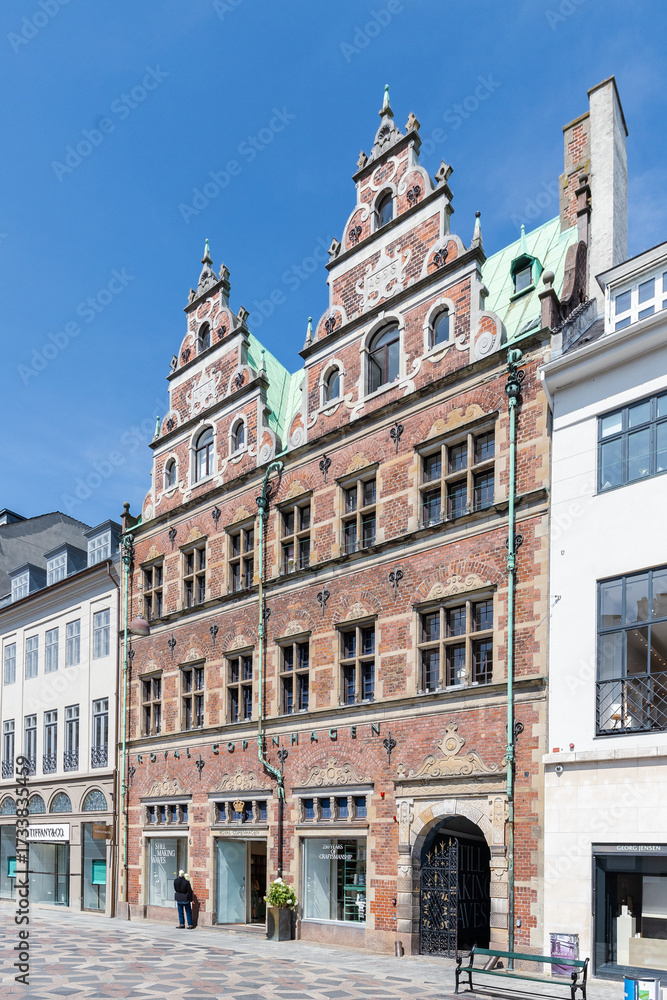 Obraz premium Copenhagen, Denmark 07-20-2025 Amagertorv is a central public square in Copenhagen, known for its medieval roots as a market square for farmers and historic buildings like the Royal Copenhagen store.