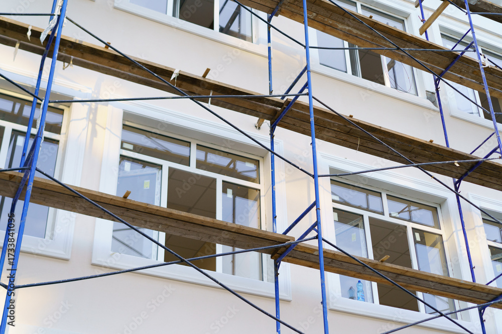 Obraz premium Building renovation in progress with scaffolding and workers preparing windows for installation