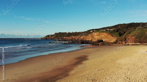Sandy beach of Australian Pacific coast at Caves beach town to sea cliff caves.
