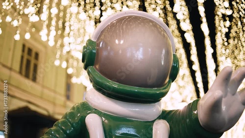 A beautiful statue of an astronaut in a spacesuit who stretches his hand towards something unknown. Close-up shooting.