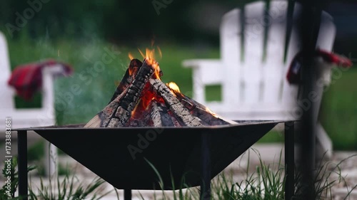 The campfire is lit in the evening in the barbecue area and its coals are smoldering. a small smoke rises. pleasant atmosphere