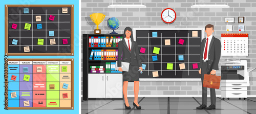 Man and woman in office standing near chalkboard with stick note. Business people presenting a financial plan. Office work concept strategy.