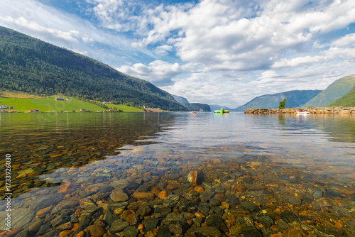 The village of Grodas in Norway, which is on the Hornindalsvatnet lake, the deepest lake of Europe and surrounded by amazing lush nature of green fields, impressive rock formations and mountains