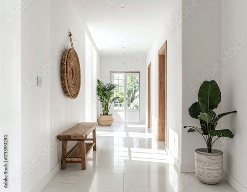 Bright White Hallway with Minimalist Decor Woven Bench Wall Art and Potted Plants with Natural Light Streaming Through Doorway