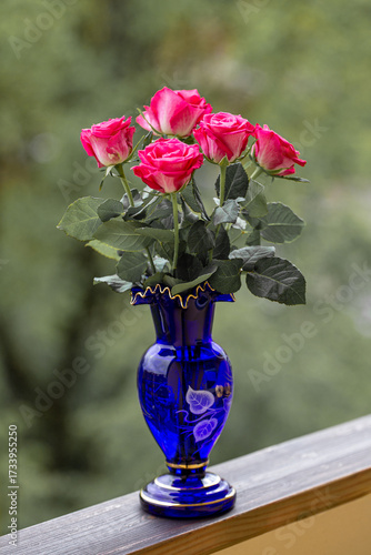 red roses in a blue glass vase